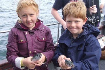 two children holding their fish