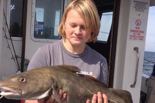 man with blond hair holding fish