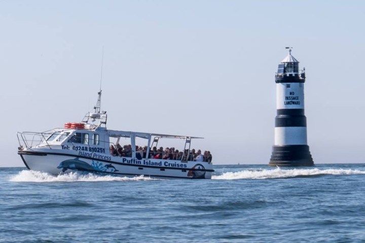 cruise boat next to lighthouse