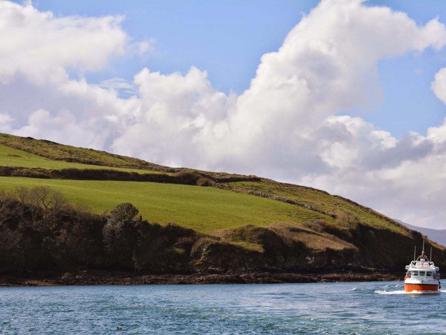 hill with boat in water